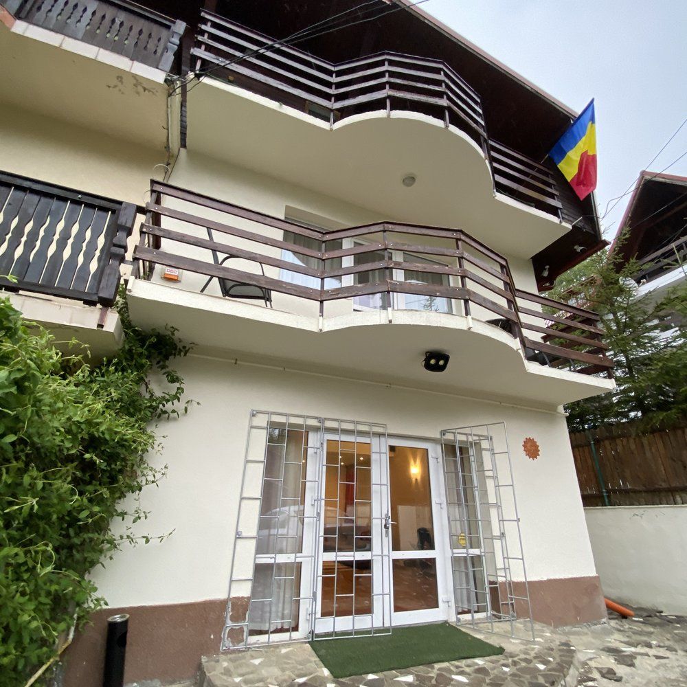 Terasa cu zonă de grătar — mese de lemn masiv pentru servirea mesei la Vila Amira